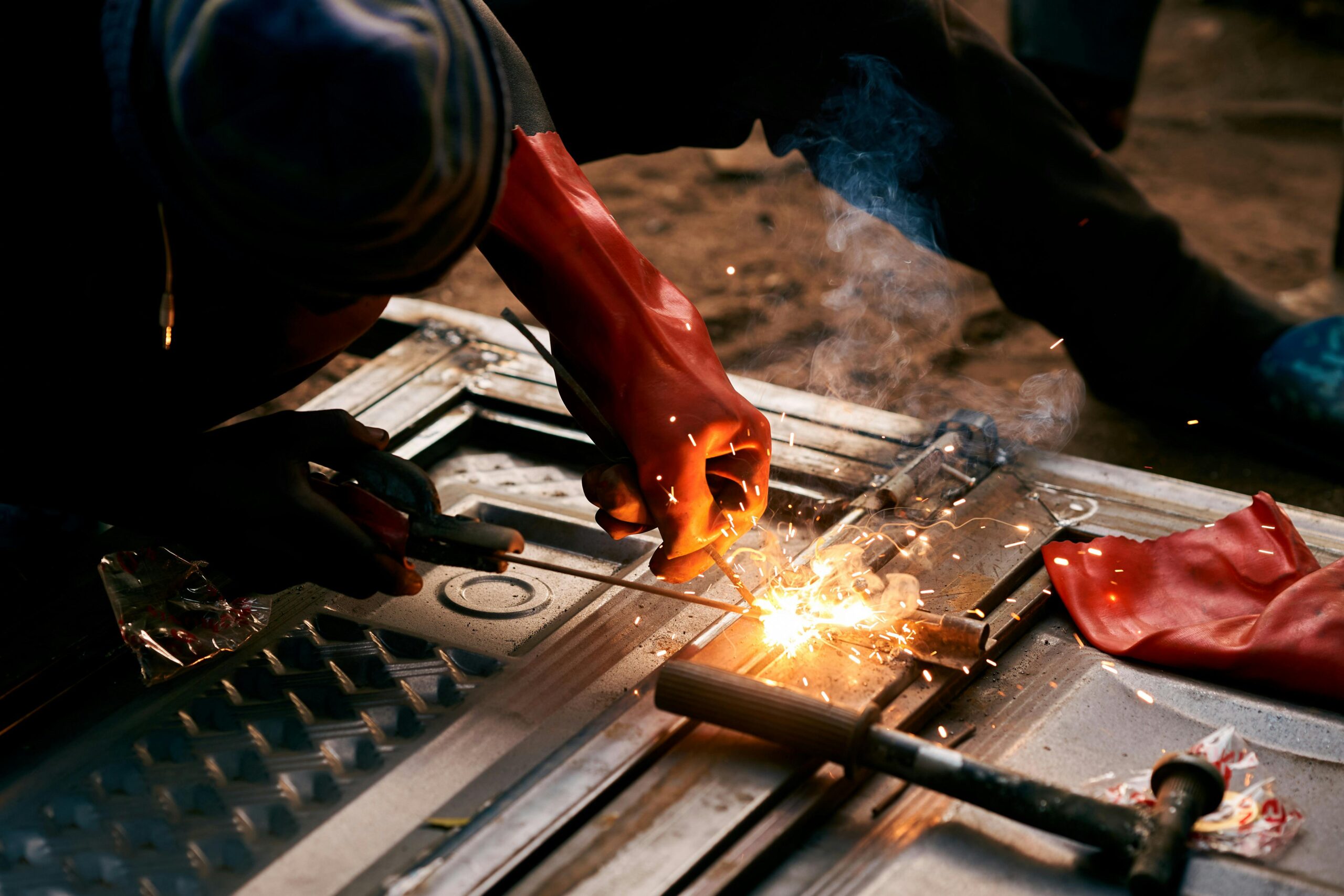 Services Close-up of an industrial worker welding metal, creating bright sparks.